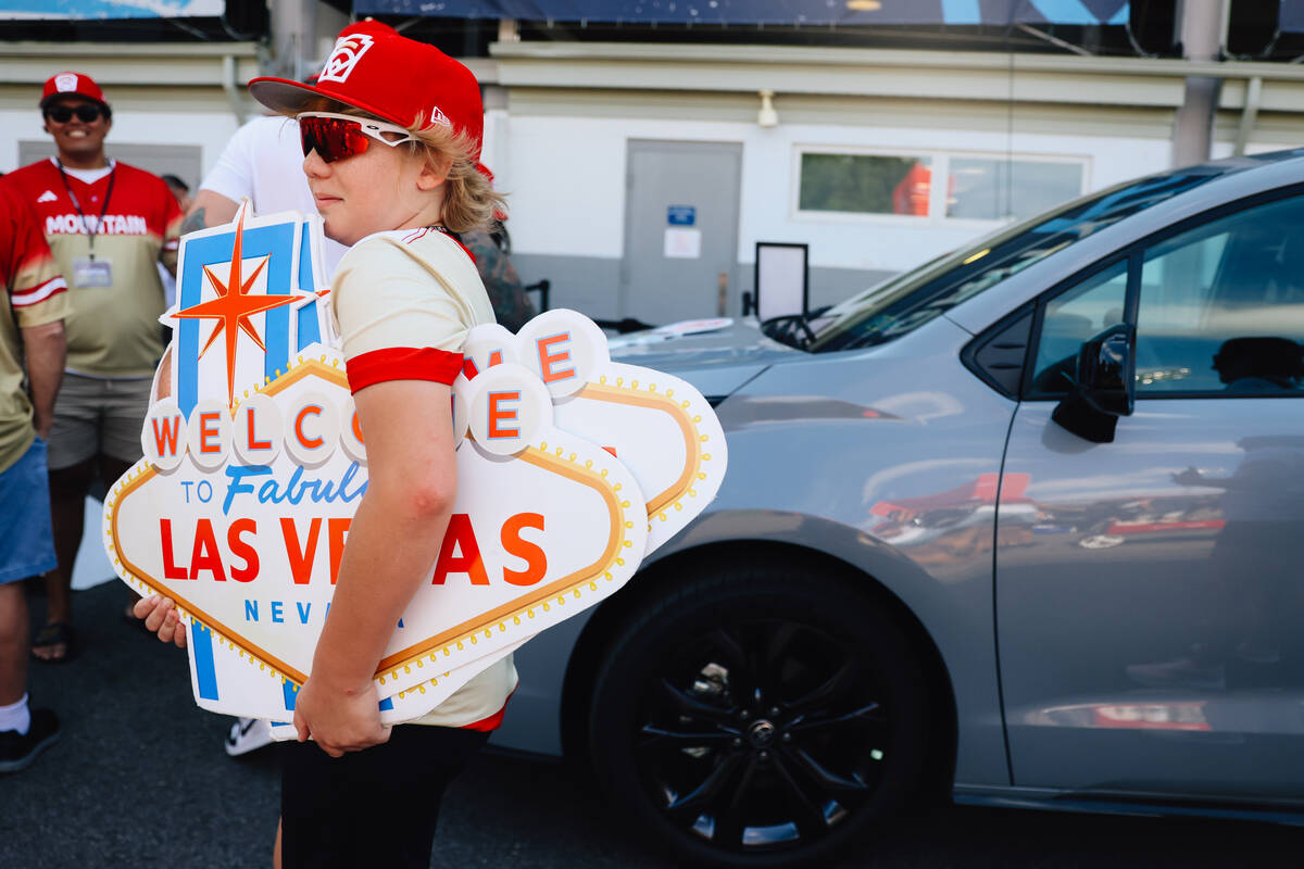 Fox Fechser, 12, carries signs into the stadium during a Little League World Series game betwee ...