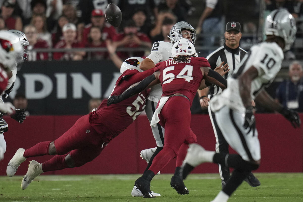 Las Vegas Raiders quarterback Aidan O'Connell is hit by Arizona Cardinals linebacker Jordan Bur ...