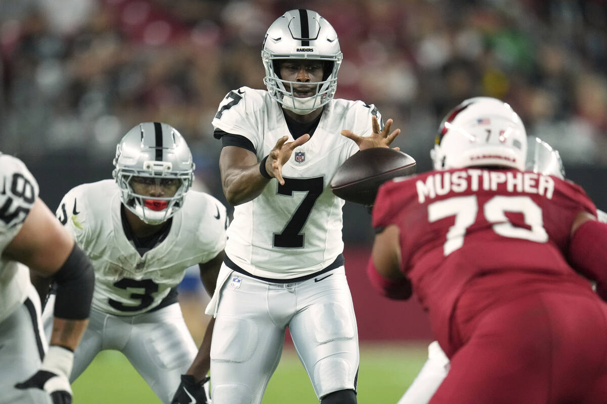 Las Vegas Raiders quarterback Geno Smith (7) takes the snap against the Arizona Cardinals durin ...