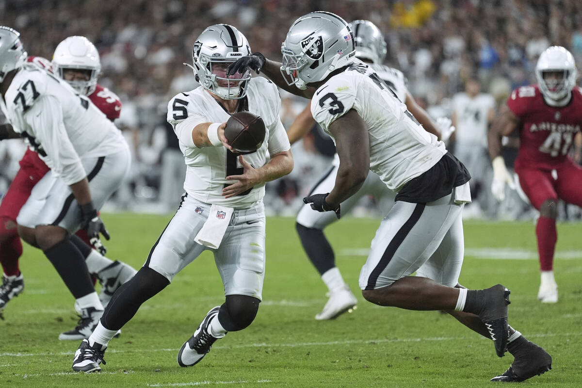 Las Vegas Raiders quarterback Cam Miller (5) hands off to running back Zamir White (3) during t ...