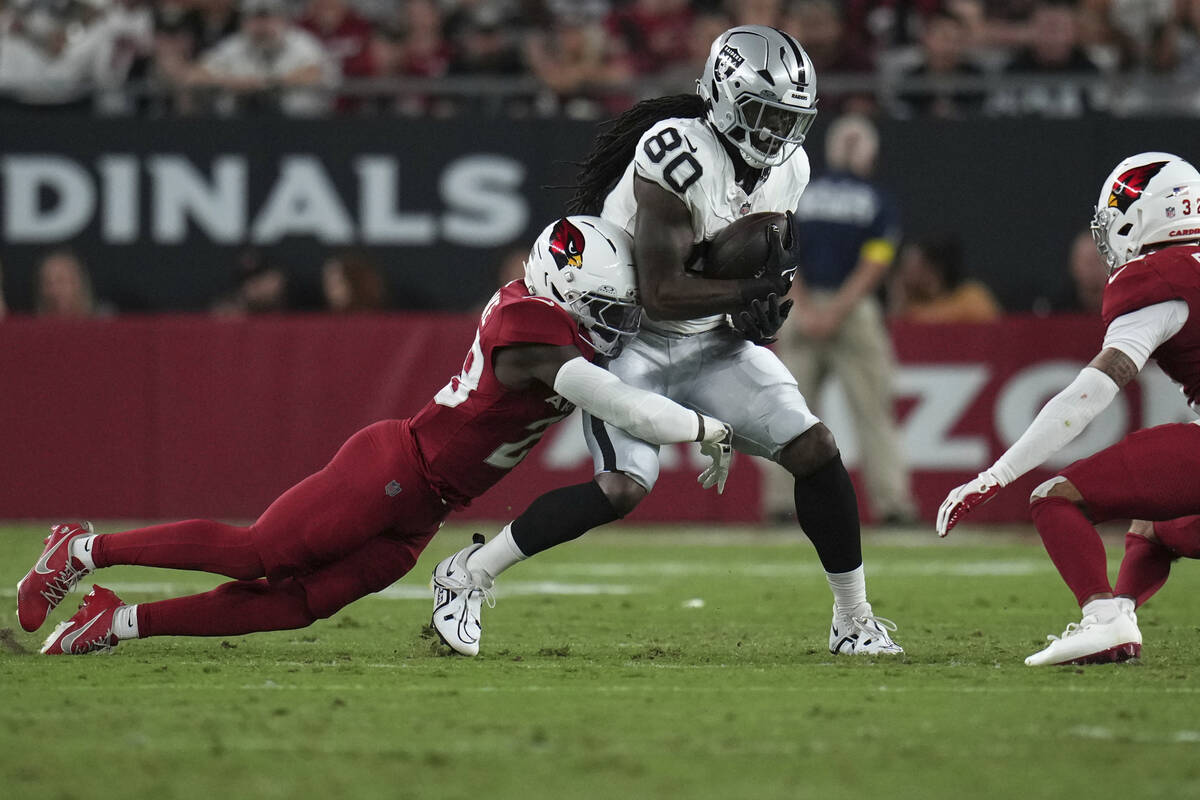 Las Vegas Raiders tight end Ian Thomas (80) is hit by Arizona Cardinals cornerback Denzel Burke ...