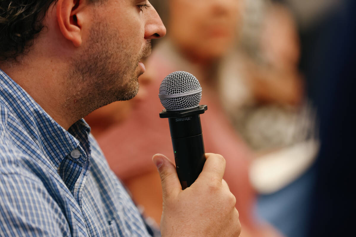 An audience member asks a question during a round table discussion for the public to discuss su ...