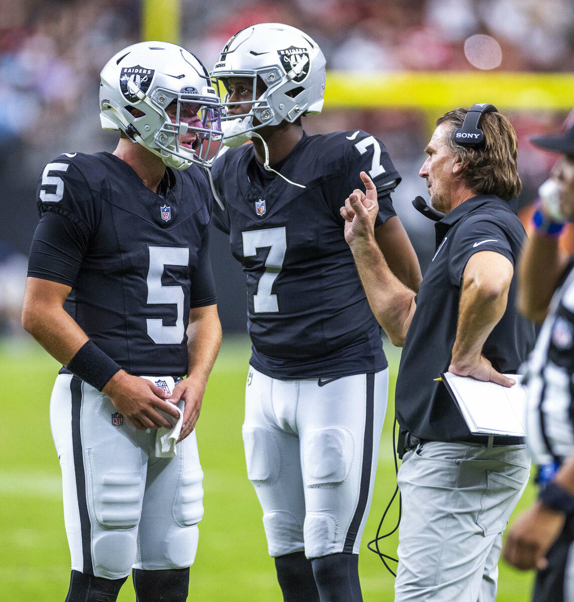Raiders quarterback Cam Miller (5) and quarterback Geno Smith (7) talks about picking up a shor ...