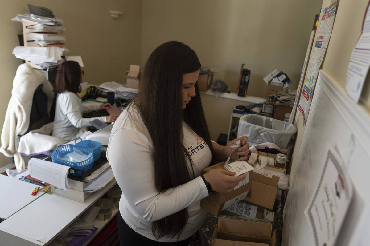 Amanda Follett works on packages at A Sight For Sore Eyes, a brick-and-mortar and ecommerce sto ...