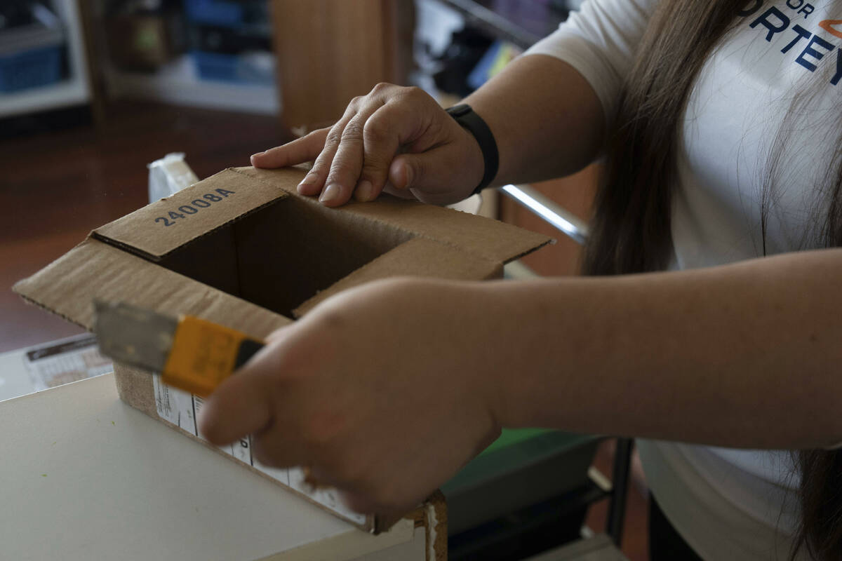 Amanda Follett opens packages at A Sight For Sore Eyes, a brick-and-mortar and ecommerce store ...