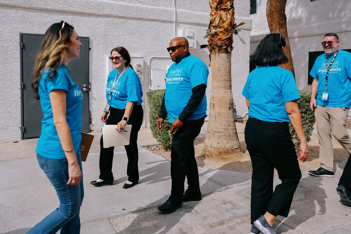 Groups of volunteers pass by each other while visiting homes on their respective lists during t ...