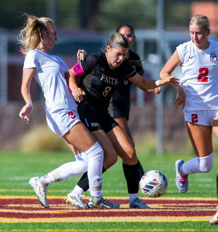 Faith Lutheran forward Olivia Stark (8) battles for the ball between Coronado midfielder Alexan ...