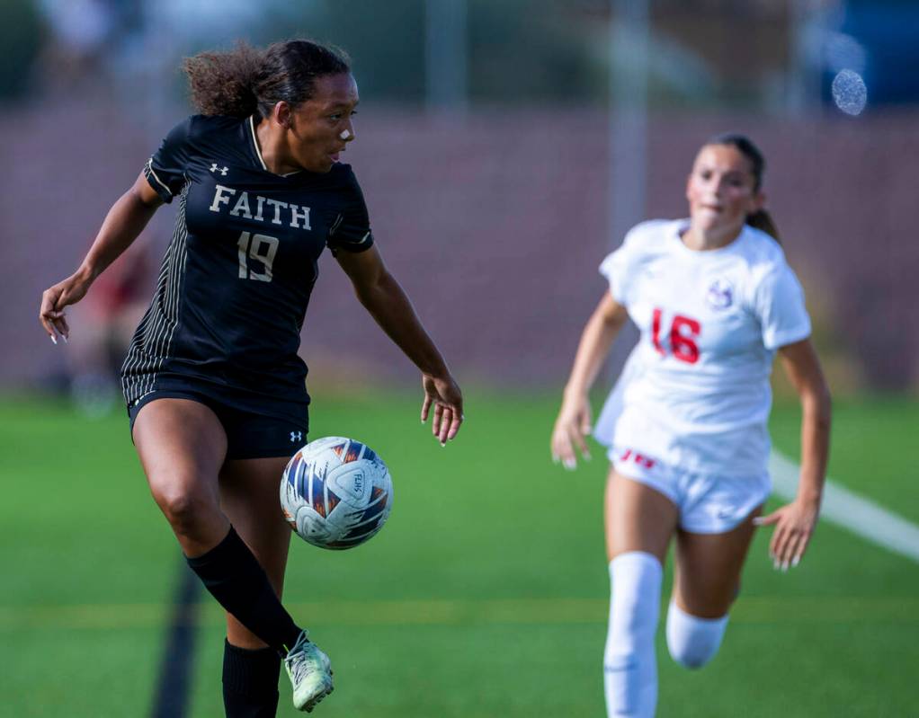Faith Lutheran forward Briana Lee (19) advances the ball as Coronado defender Mia Schlachter (1 ...