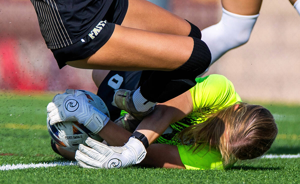 Coronado goalkeeper Liliana Foss (0) secures a shot attempt by Faith Lutheran forward Elliott L ...