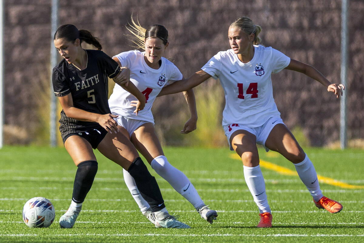 Faith Lutheran defender Posie Armstrong (5) looks to the ball while battling Coronado defender ...