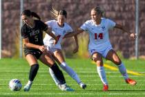 Faith Lutheran defender Posie Armstrong (5) looks to the ball while battling Coronado defender ...