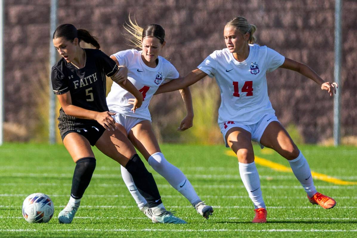 Faith Lutheran defender Posie Armstrong (5) looks to the ball while battling Coronado defender ...