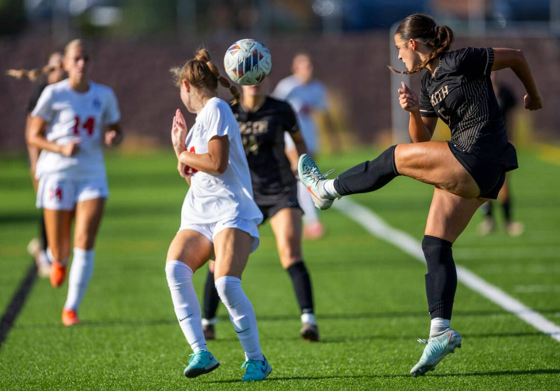 Faith Lutheran defender Posie Armstrong (5) kicks the ball past a Coronado defender during the ...