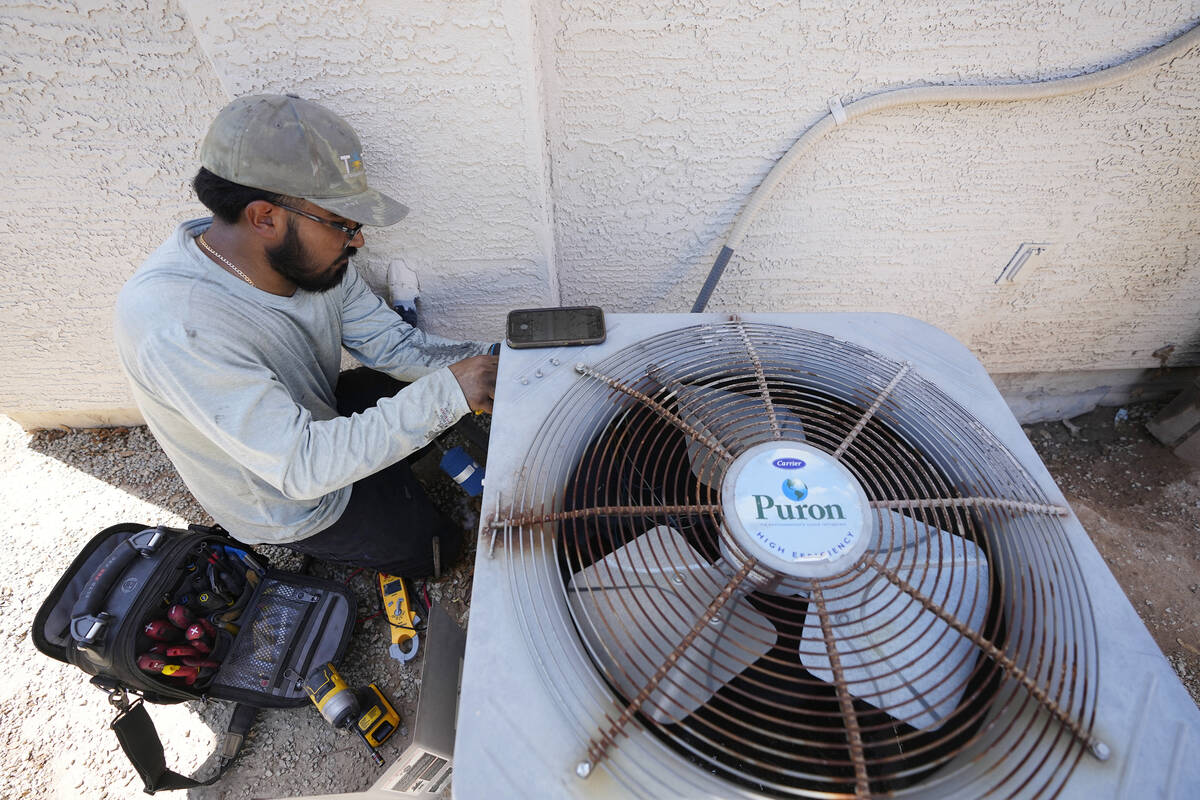 Total Refrigeration service tech Michael Villa works on replacing a fan motor on an air conditi ...