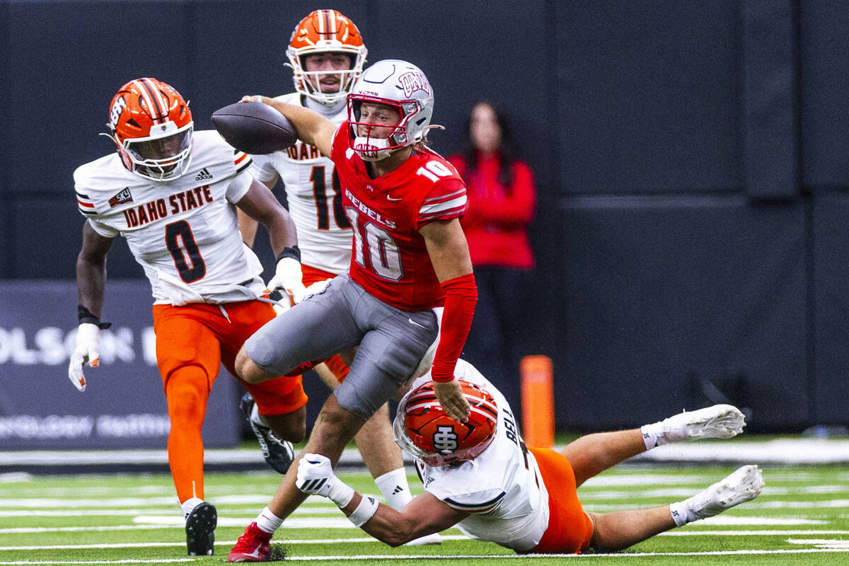 UNLV quarterback Anthony Colandrea (10) breaks free from a tackle attempt by Idaho State Bengal ...