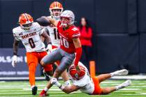 UNLV quarterback Anthony Colandrea (10) breaks free from a tackle attempt by Idaho State Bengal ...