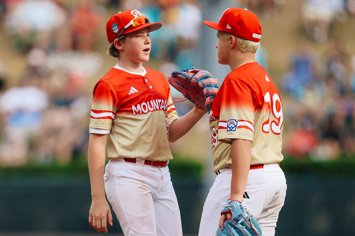 Summerlin South left fielder Banks Mossler (8) speaks with teammate and pitcher Garrett Gallego ...