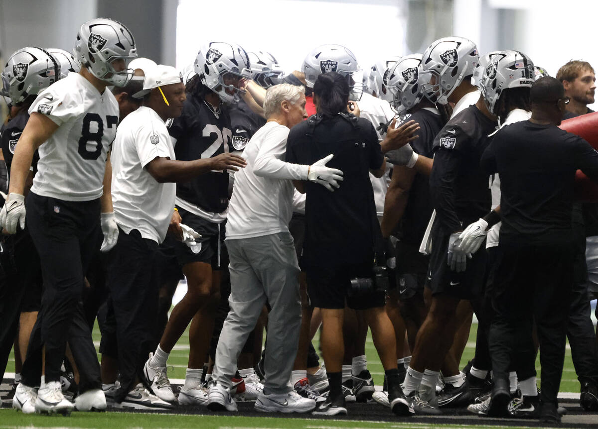 Raiders head coach Pete Carroll, center, huddles with players prior to team practice at the Int ...