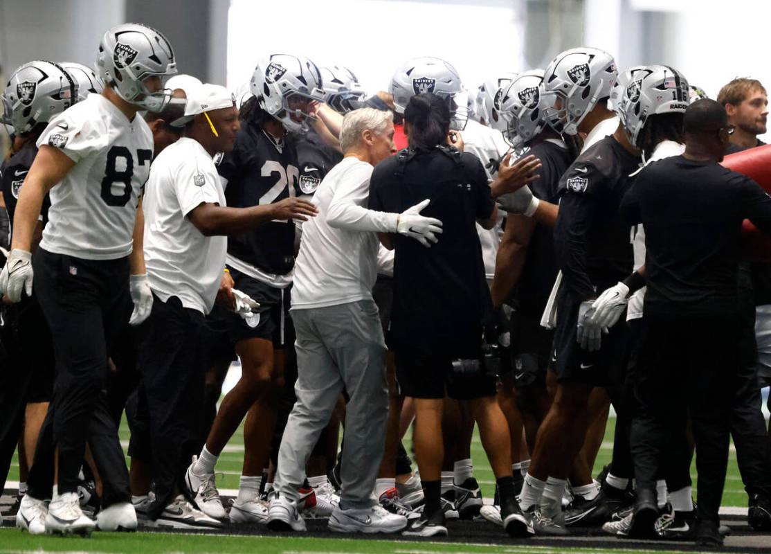 Raiders head coach Pete Carroll, center, huddles with players prior to team practice at the Int ...