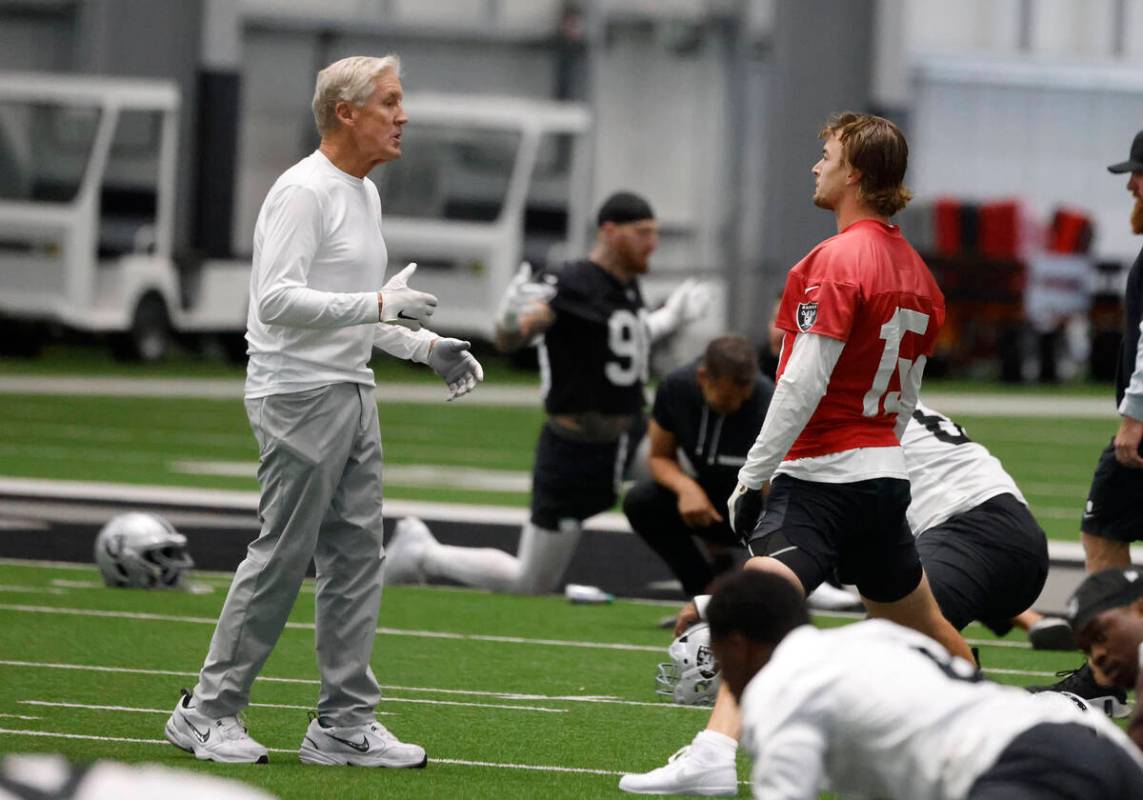 Raiders head coach Pete Carroll, left, chats with backup quarterback Kenny Pickett (15) during ...