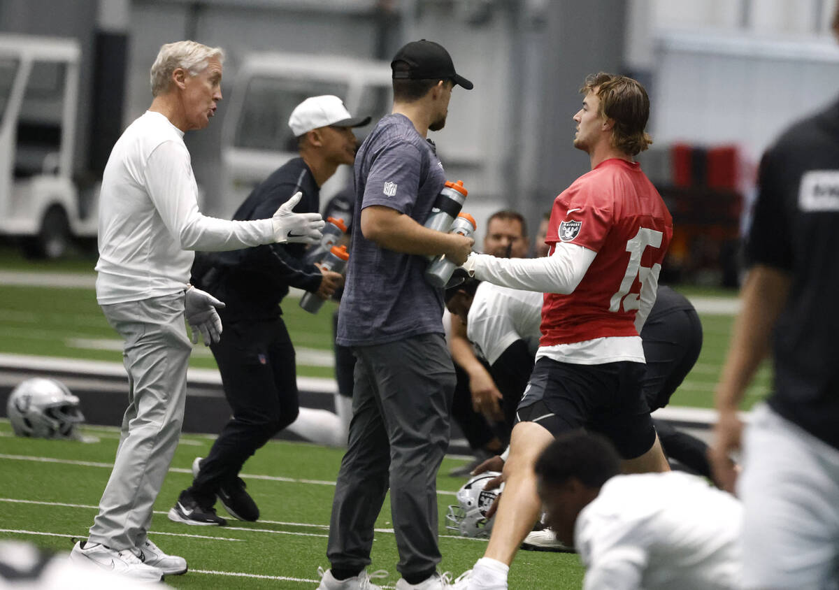 Raiders head coach Pete Carroll, left, chats with backup quarterback Kenny Pickett (15) during ...
