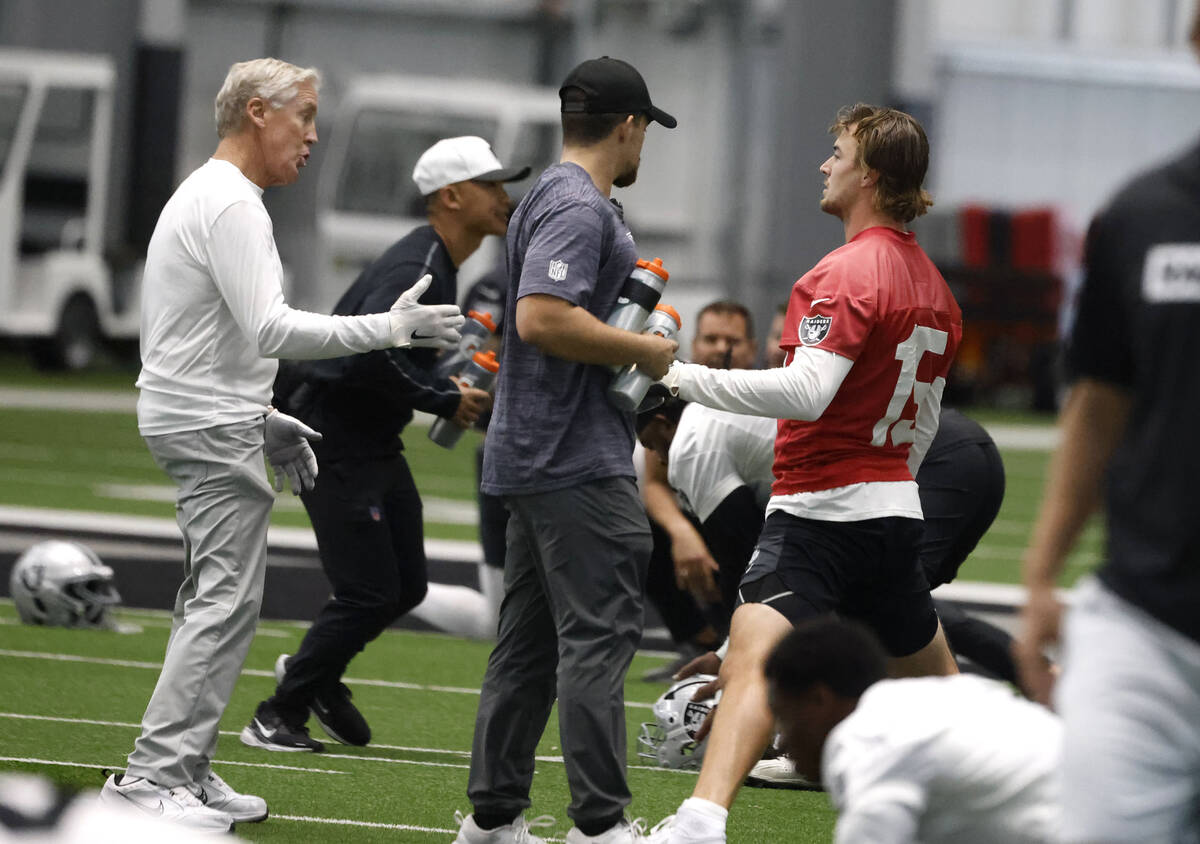 Raiders head coach Pete Carroll, left, chats with backup quarterback Kenny Pickett (15) during ...