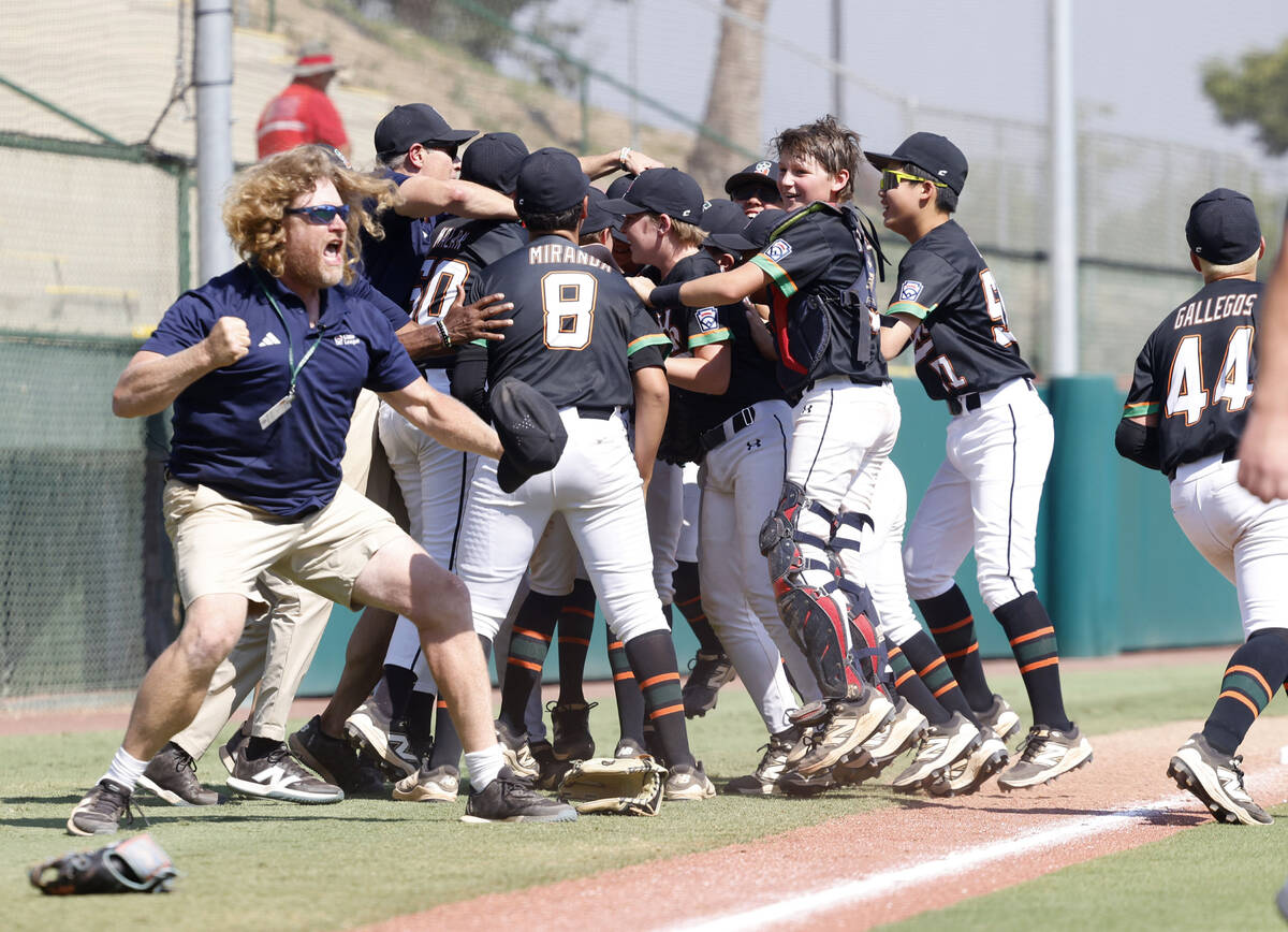Nevada team head coach TJ Fechser, left, celebrates with his players after winning 6-3 against ...