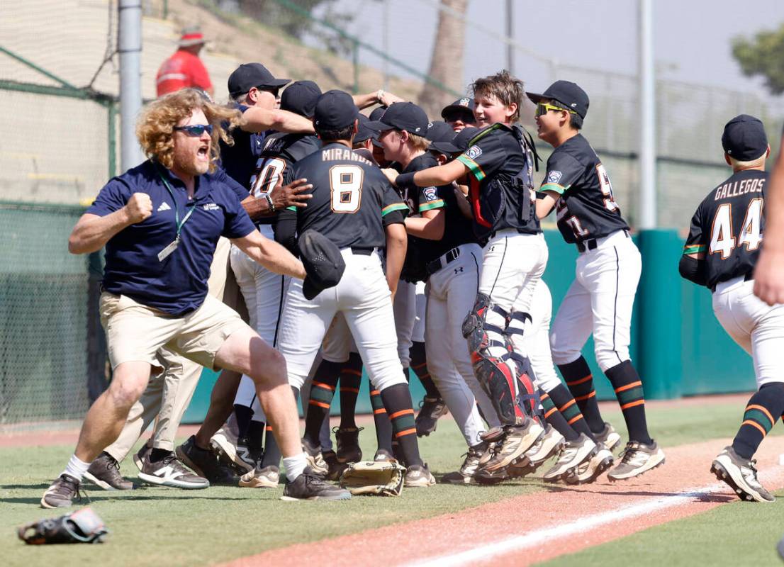 Nevada team head coach TJ Fechser, left, celebrates with his players after winning 6-3 against ...