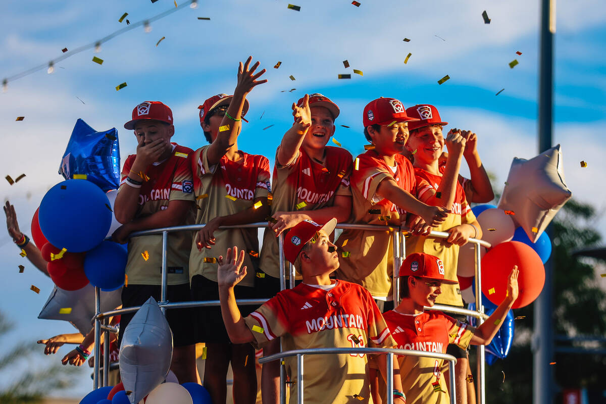 The Summerlin South baseball team waves and grabs confetti during a parade in honor of their Li ...