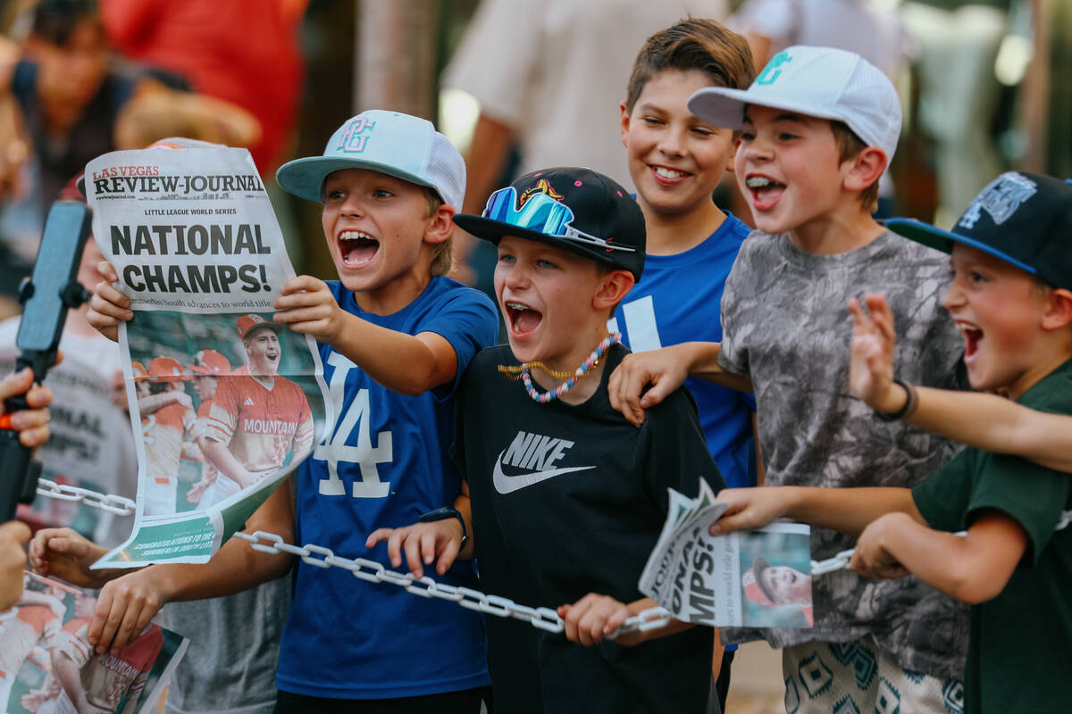 Kids shout and hold up the front page of the Review-Journal for cameras during the parade celeb ...
