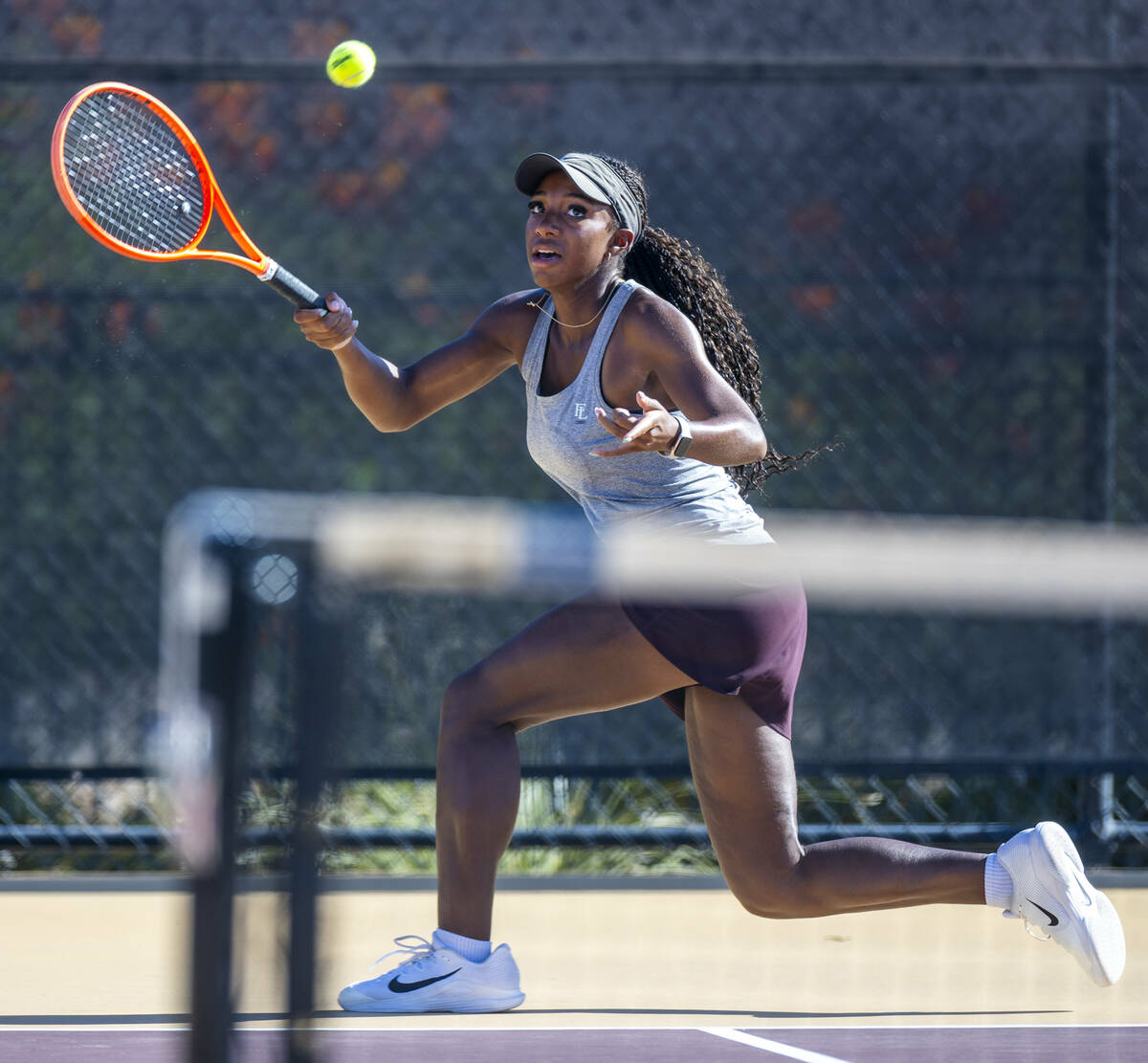 Faith Lutheran's Zoe Slushers tracks down a ball against Bishop Gorman during their singles NIA ...