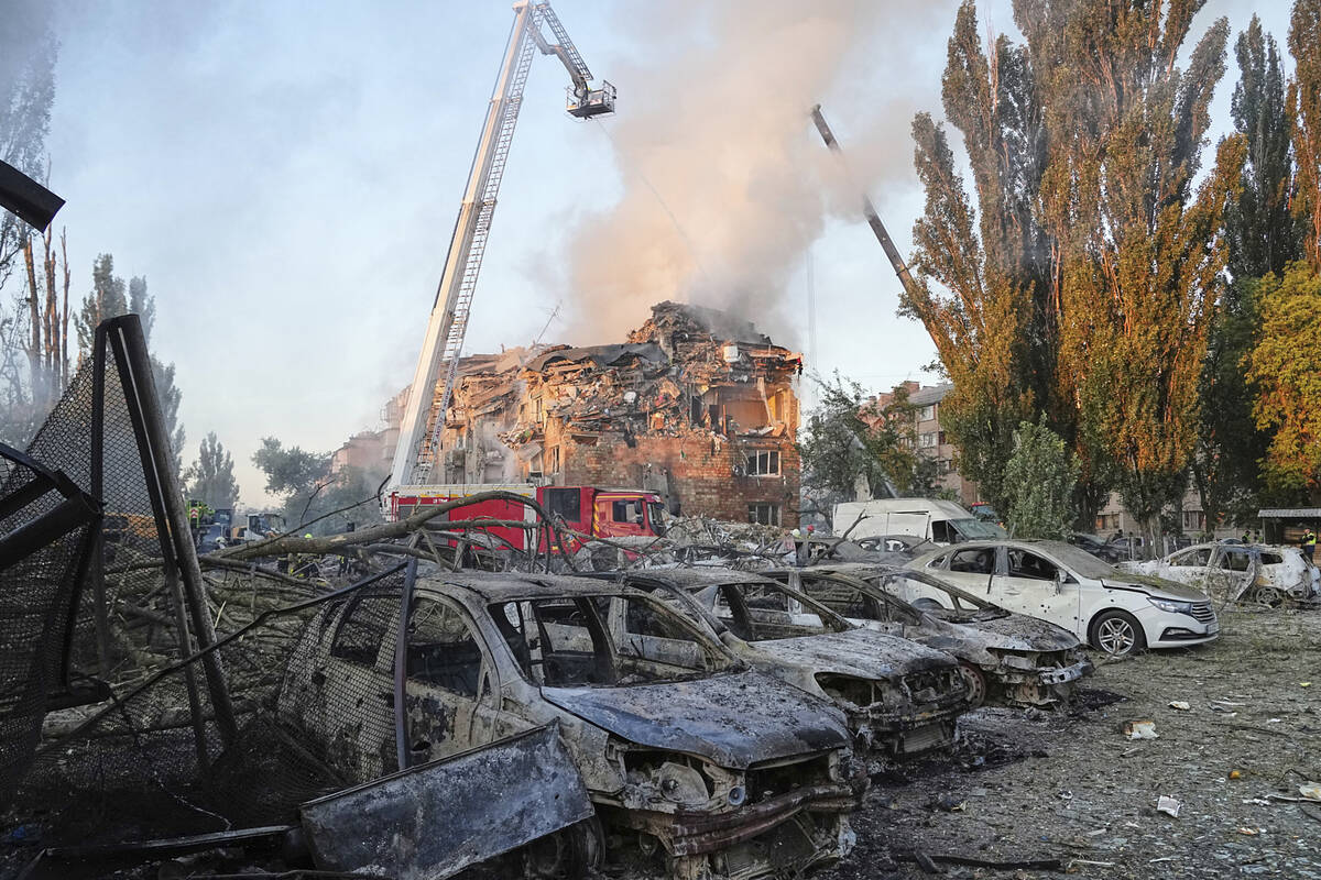 Firefighters work on the site of a burning building after a Russian attack in Kyiv, Ukraine, ea ...