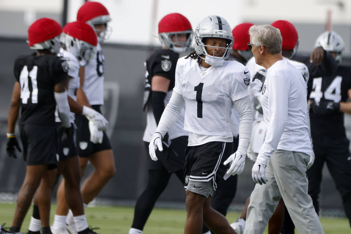 Raiders head coach Pete Carroll discusses with wide receiver Tre Tucker (1) during team practic ...