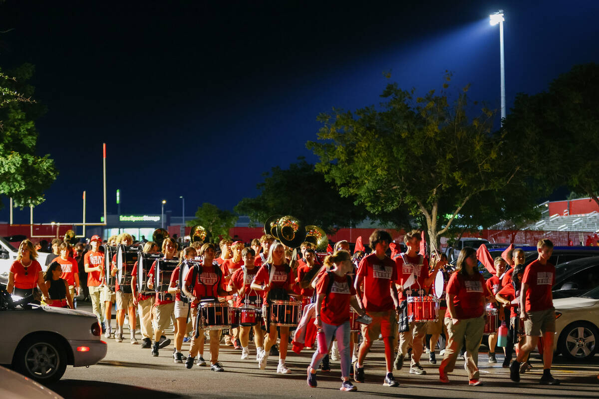 The Arbor View marching band, with the drum line still drumming, marches through the parking lo ...