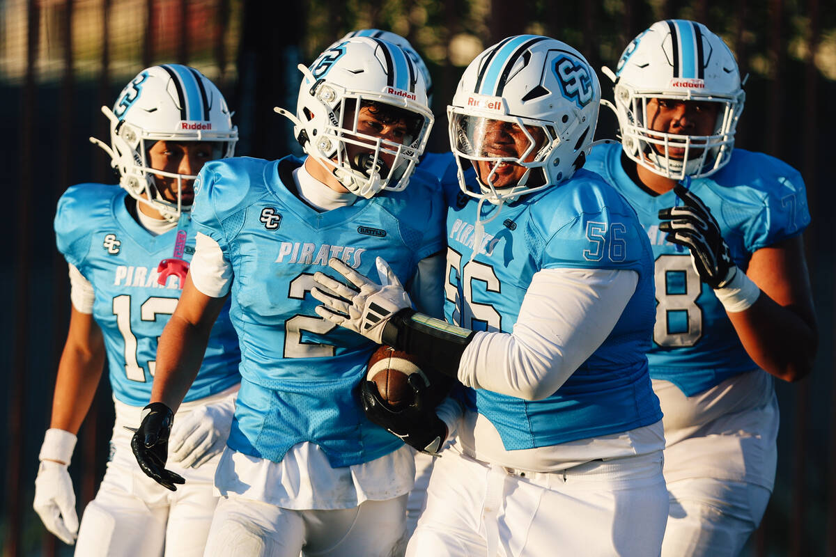 Sloan Canyon teammates celebrate wide receiver Brandon Quaglio (2) during a high school footbal ...