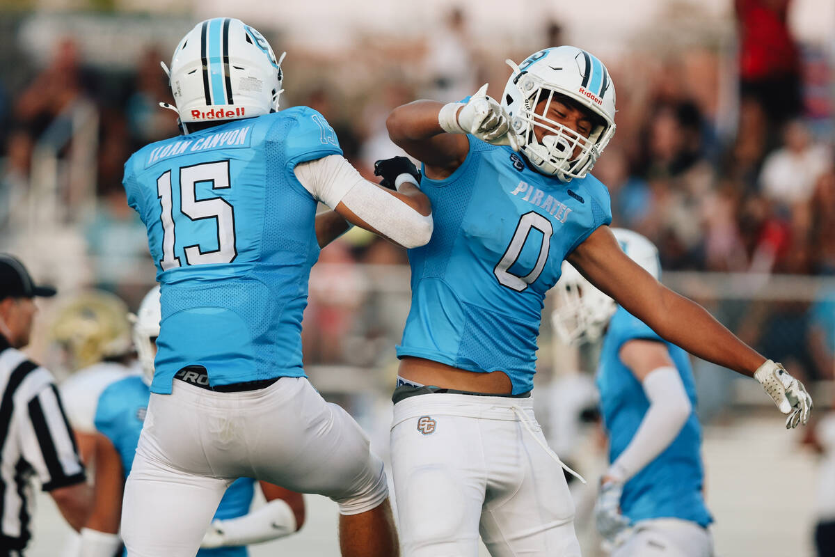 Sloan Canyon’s Gavin Rhodes (15) and Kame’e Sawyer-Mahoe celebrate during a high ...
