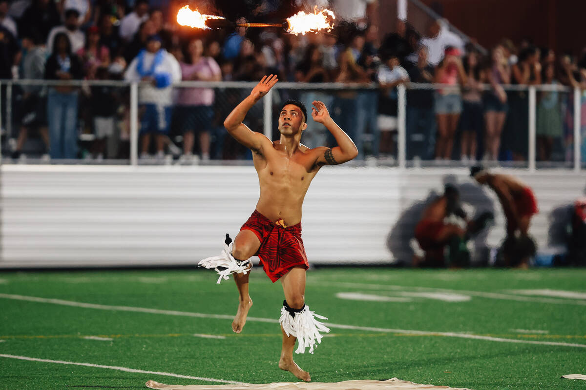 A fire dancer entertains a crowd during a high school football game between Sloan Canyon and Fo ...