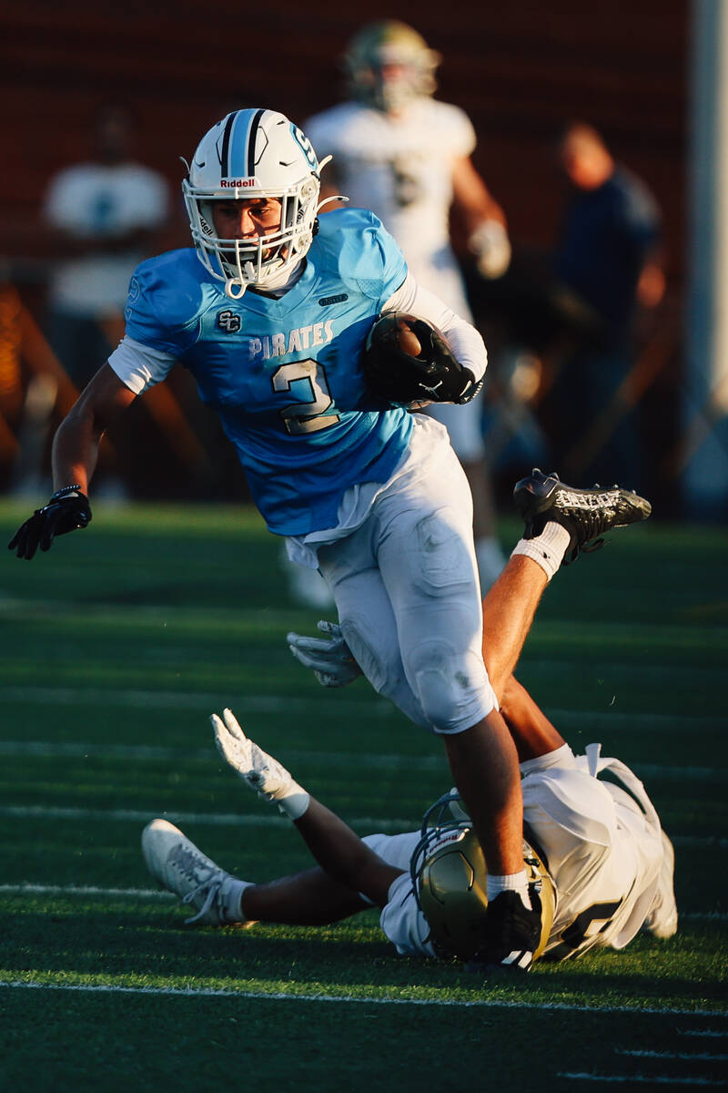 Sloan Canyon wide receiver Brandon Quaglio powers past a defender during a high school football ...