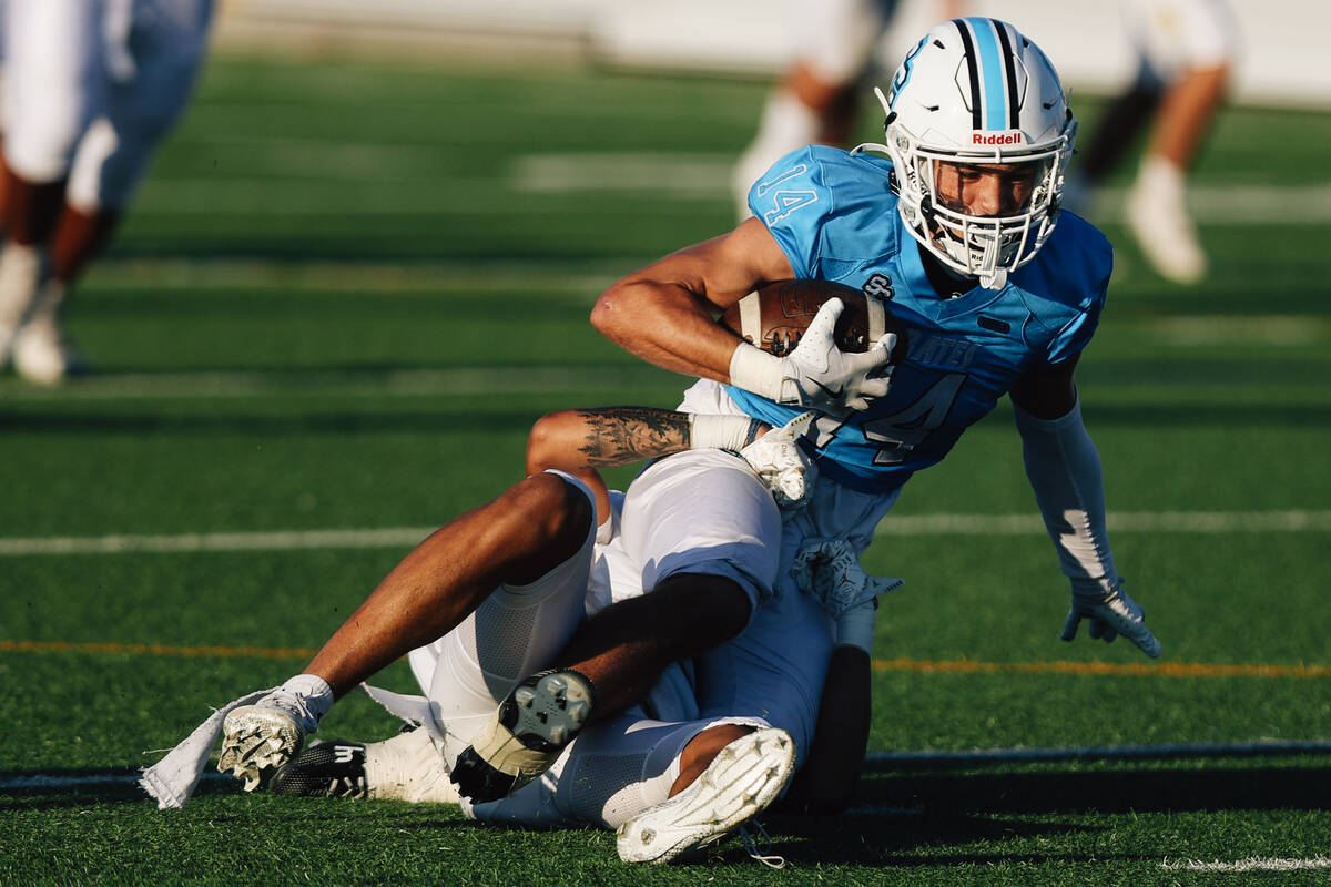 Sloan Canyon wide receiver Christian Rhodes gets taken down during a high school football game ...
