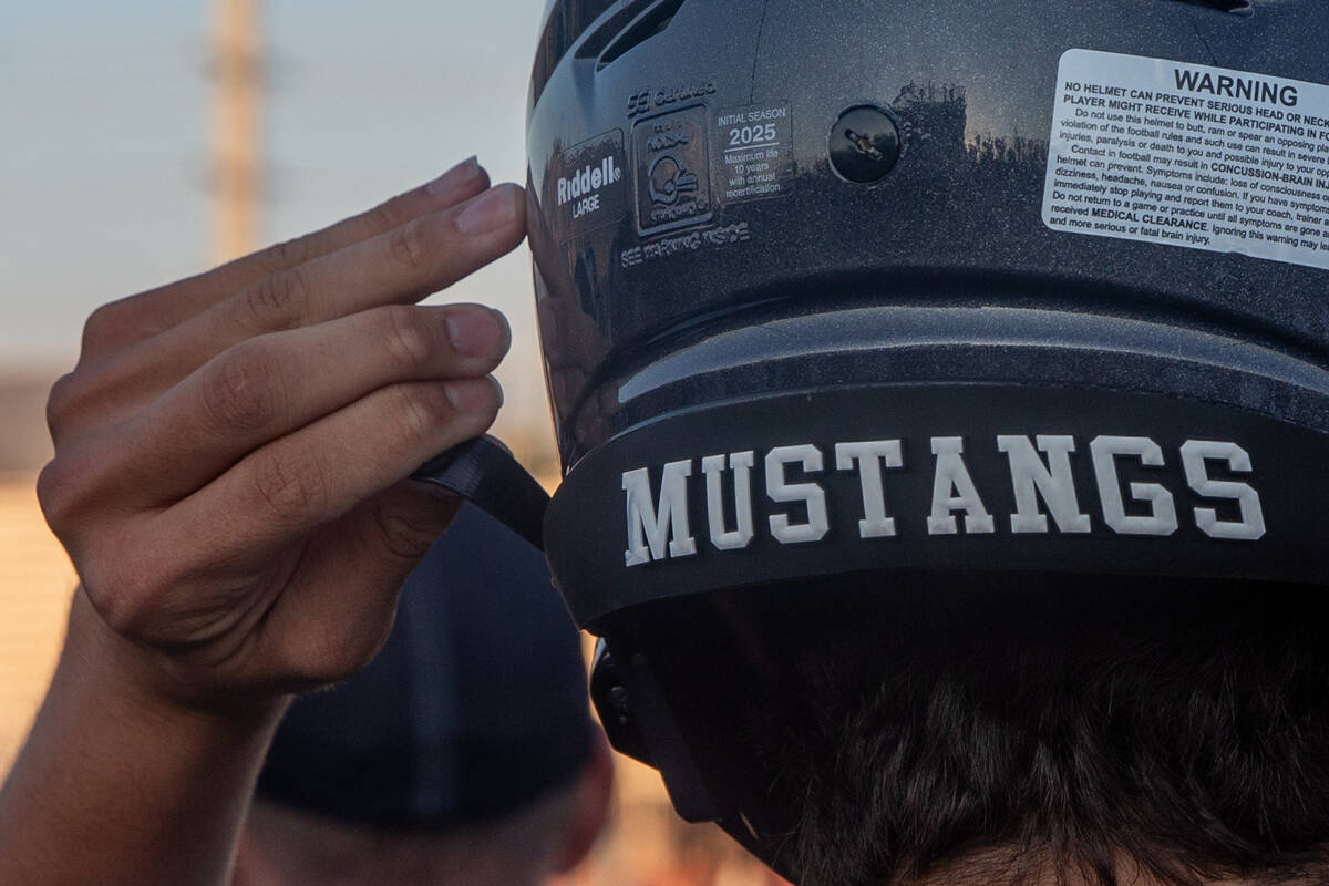 A Shadow Ridge player clips his helmet during a football game between Shadow Ridge and Simi Val ...