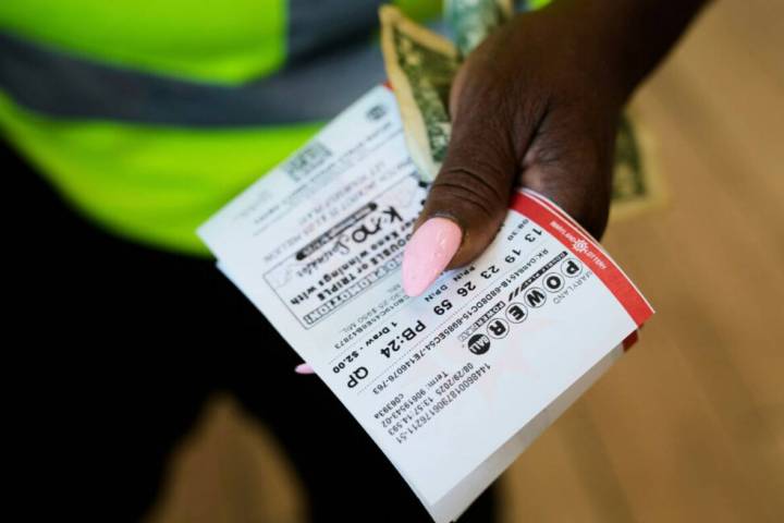 Roslyn Jefferson holds her Powerball lottery tickets ahead of Saturday's Powerball drawing offe ...