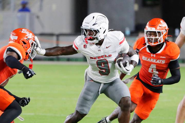 UNLV running back Jai'Den Thomas (9) pushes off Sam Houston State defensive back Alonzo Edwards ...