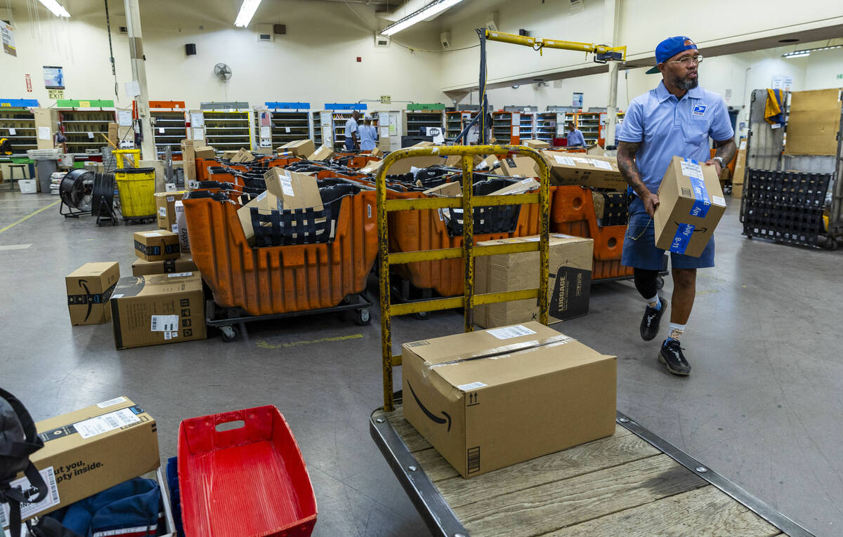 Ishe Smith gathers all the parcels he will deliver on his route as a mail carrier while startin ...