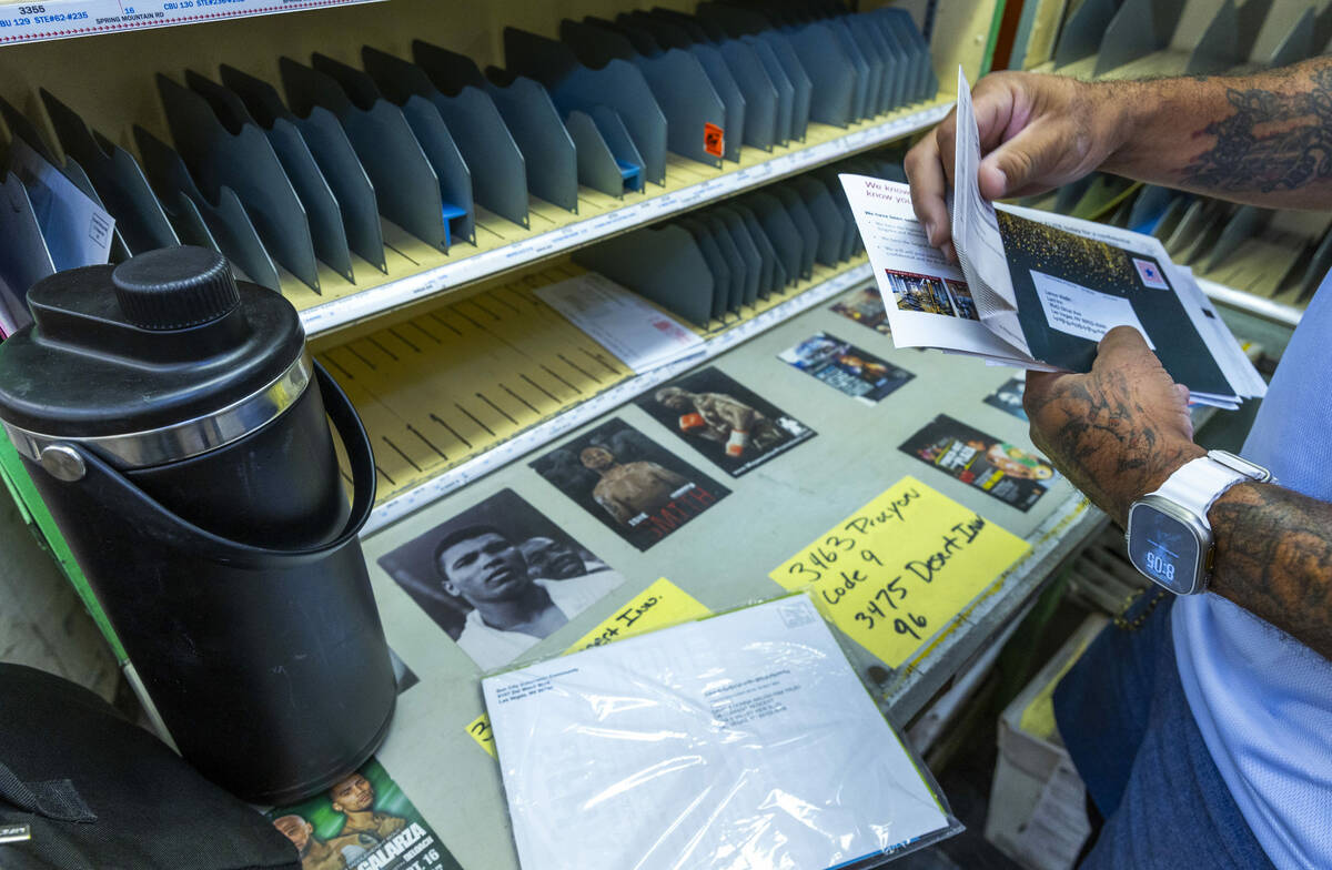 Ishe Smith gathers sorts the mail he will deliver on his route as a mail carrier while starting ...