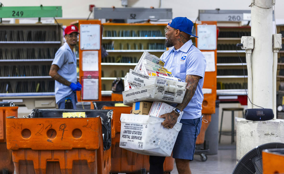 Ishe Smith gathers the mail he will deliver on his route as a mail carrier while starting his s ...