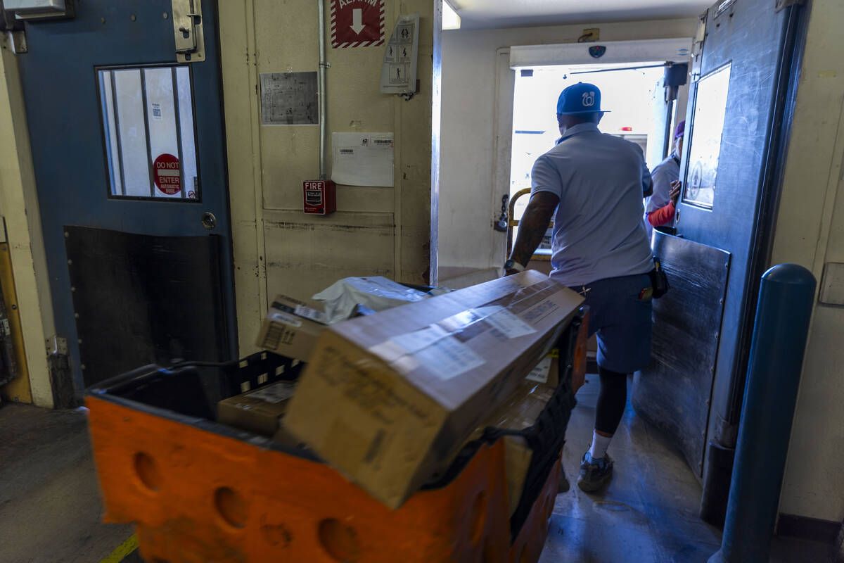 Ishe Smith transports the mail he will deliver on his route as a mail carrier to his truck whil ...