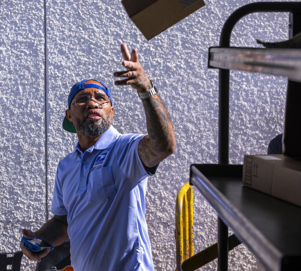 Ishe Smith separates the mail he will deliver on his route as a mail carrier into bins in his t ...