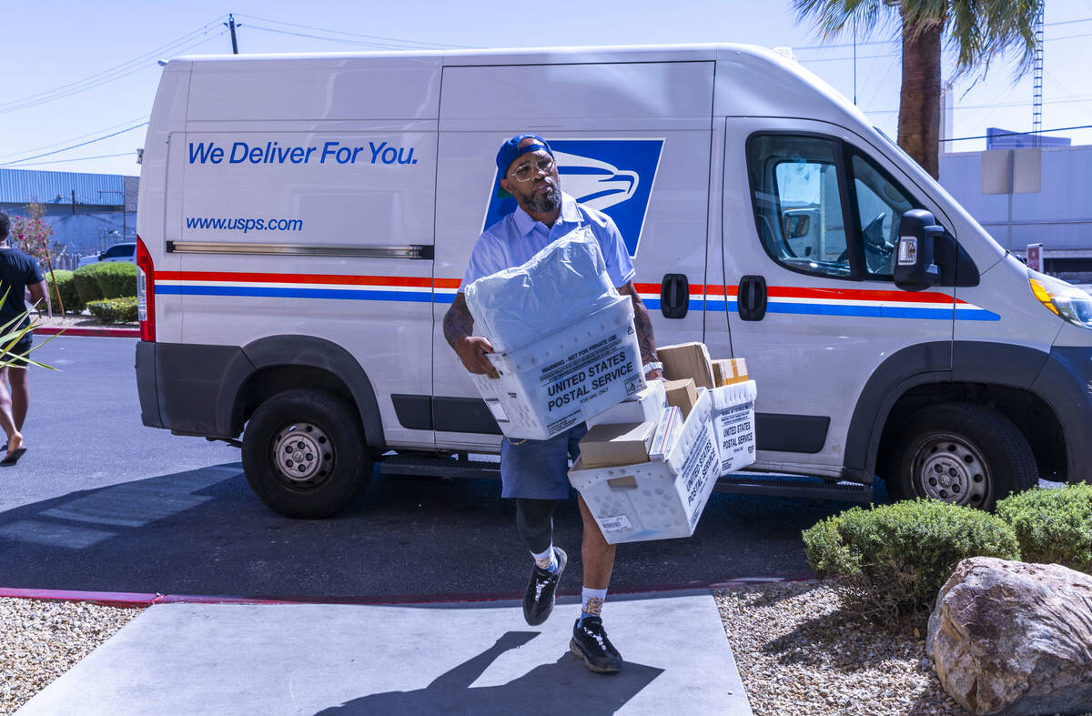 Ishe Smith makes a stop along his route as a mail carrier on Wednesday, July 30, 2025, in Las V ...