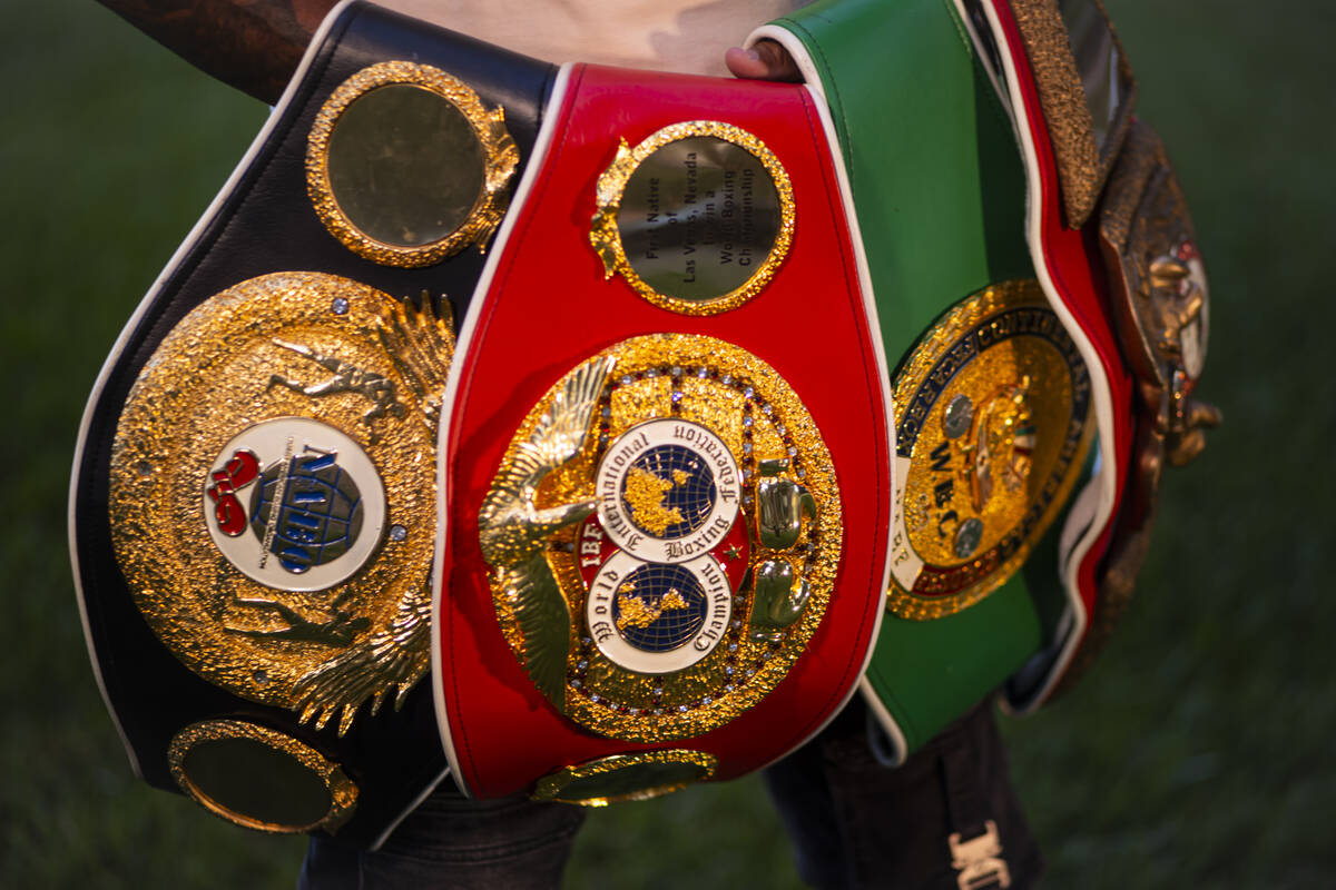 Former pro boxer Ishe Smith holds his belts while posing for a photo near his home on Wednesday ...