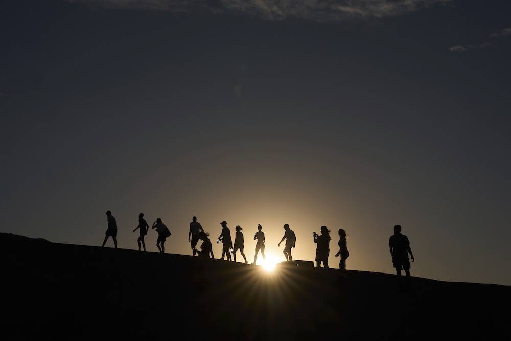 People walk up to an overlook at Zabriskie Point, Sunday, Aug. 3, 2025, in Death Valley Nationa ...